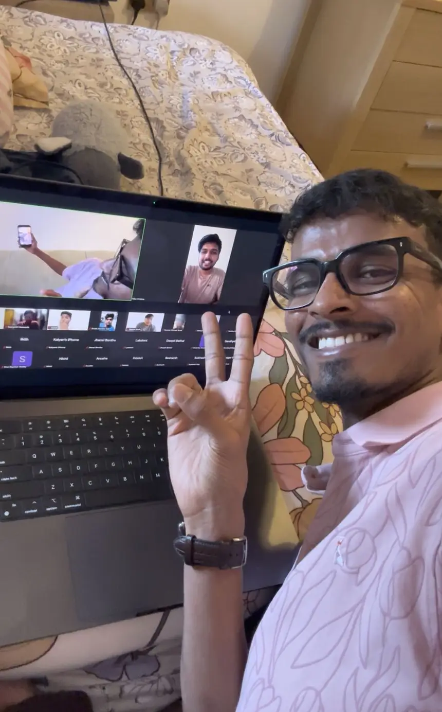 Vasu on a video call with a grid of students on the screen behind him.