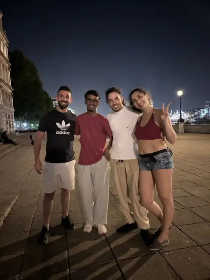 Vasu with three friends on a London street at night.